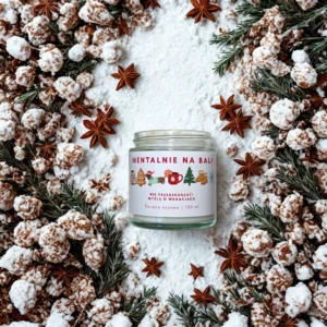 Świeca sojowa Mentalnie na Bali w zimowej aranżacji z gwiazdkami anyżu, gałązkami świerku i śnieżnymi dekoracjami.